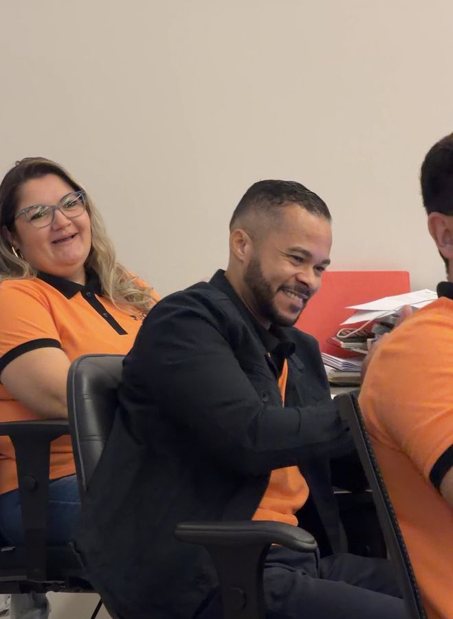 Colaboradores sorrindo em uma reunião